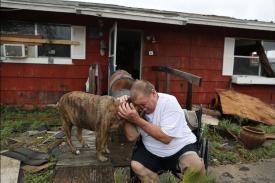 Man hugging dog following Hurricane Harvey