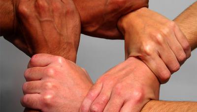 Image of multiple people linking hands