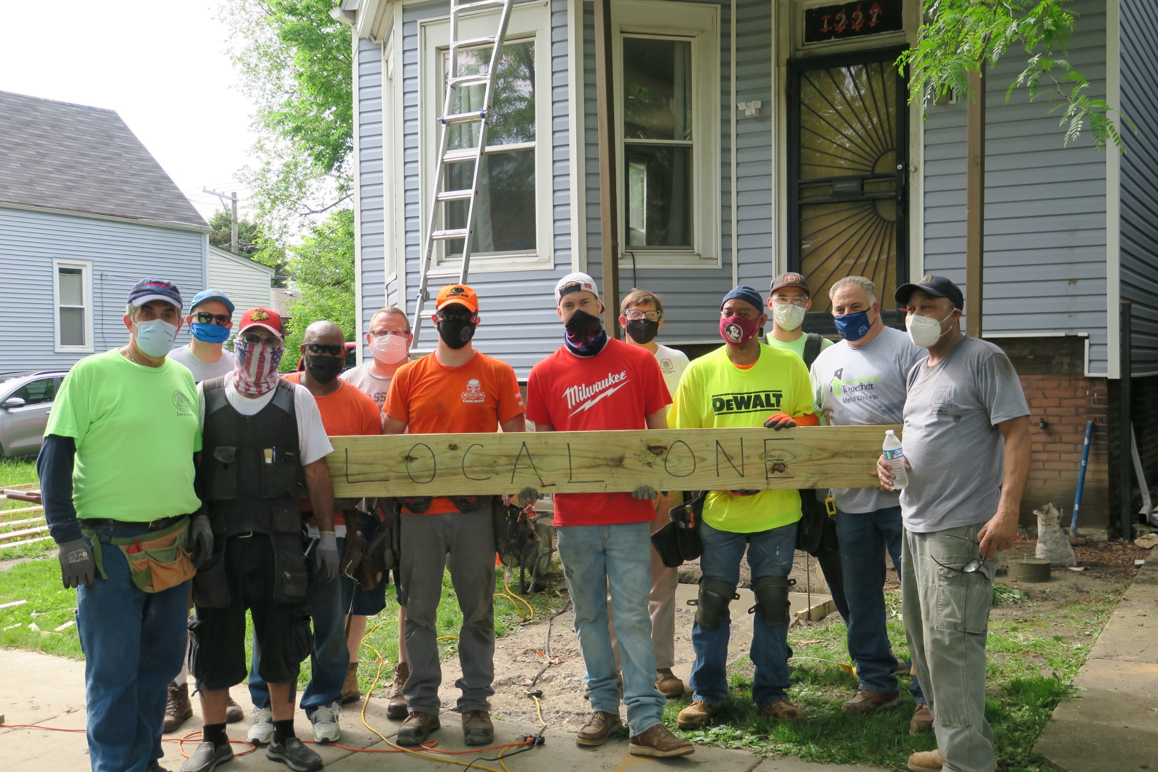 Local One union members pose together outside of house