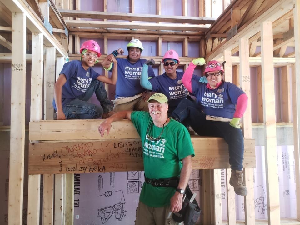 Carpenters with the Chicago Sisterhood of Carpenters pose together inside a house