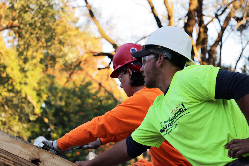 Two carpenters working on a roof