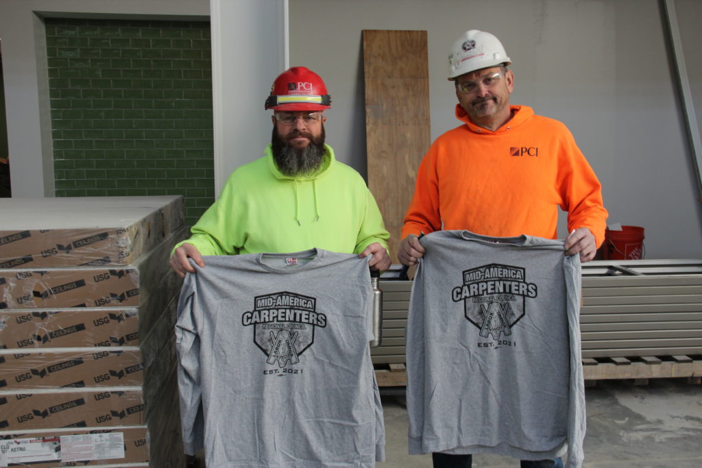 carpenters smiling for photo with shirts