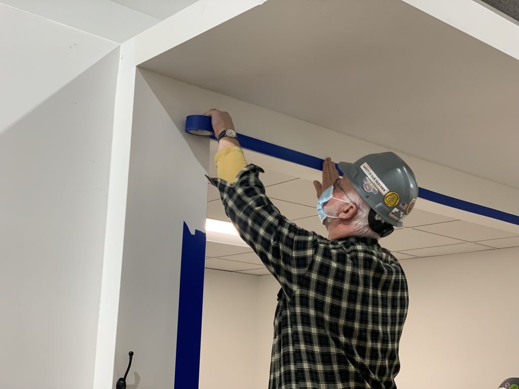 Carpenter placing tape on walls